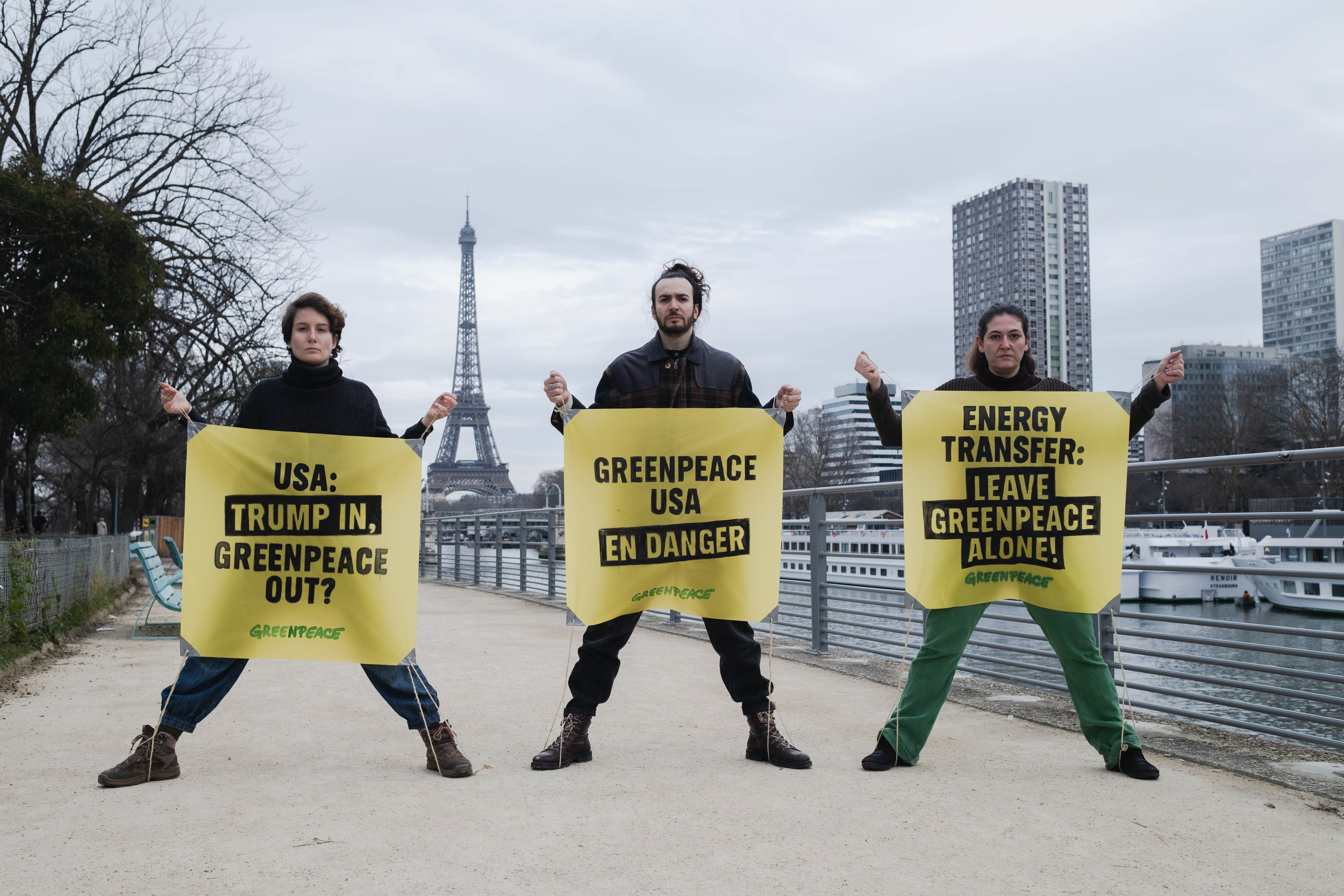 Devant la tour Eiffel, des militants de Greenpeace France déploient des banderoles avec des messages de soutien à Greenpeace USA.